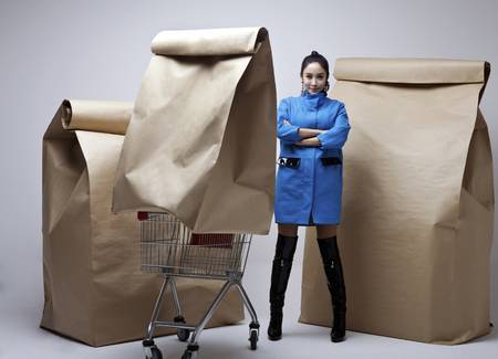 68134242-a-woman-in-blue-surrounded-by-giant-brown-bags.jpg