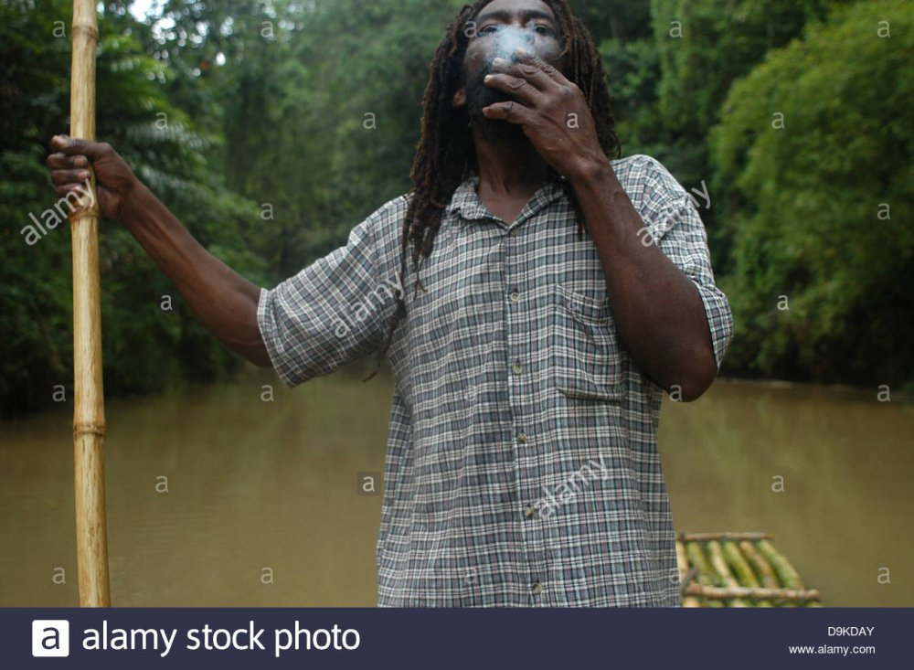 rasta-man-smoking-a-joint-of-marijuana-at-bamboo-rafting-great-river-D9KDAY.jpg