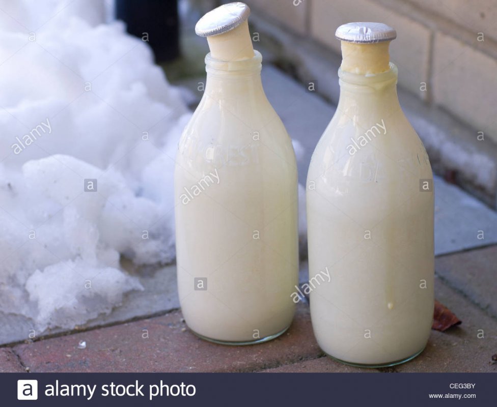 two-bottles-of-milk-frozen-on-a-doorstep-in-winter-CEG3BY.jpg