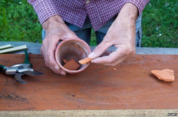 Man puts terracotta pieces into pot