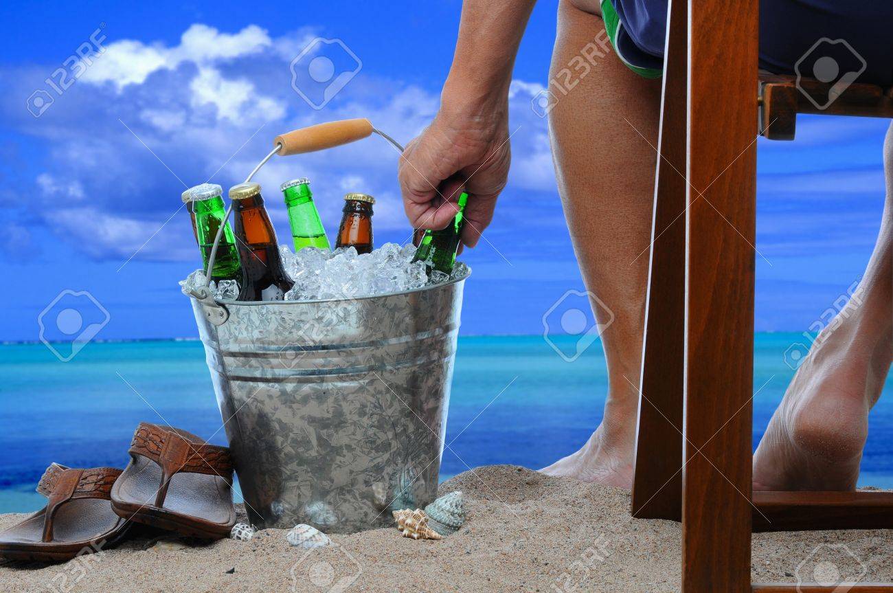 8680585-Close-up-of-a-man-sitting-in-a-wooden-chair-at-the-beach-reaching-into-a-bucket-filled-with-ice-and--Stock-Photo.jpg